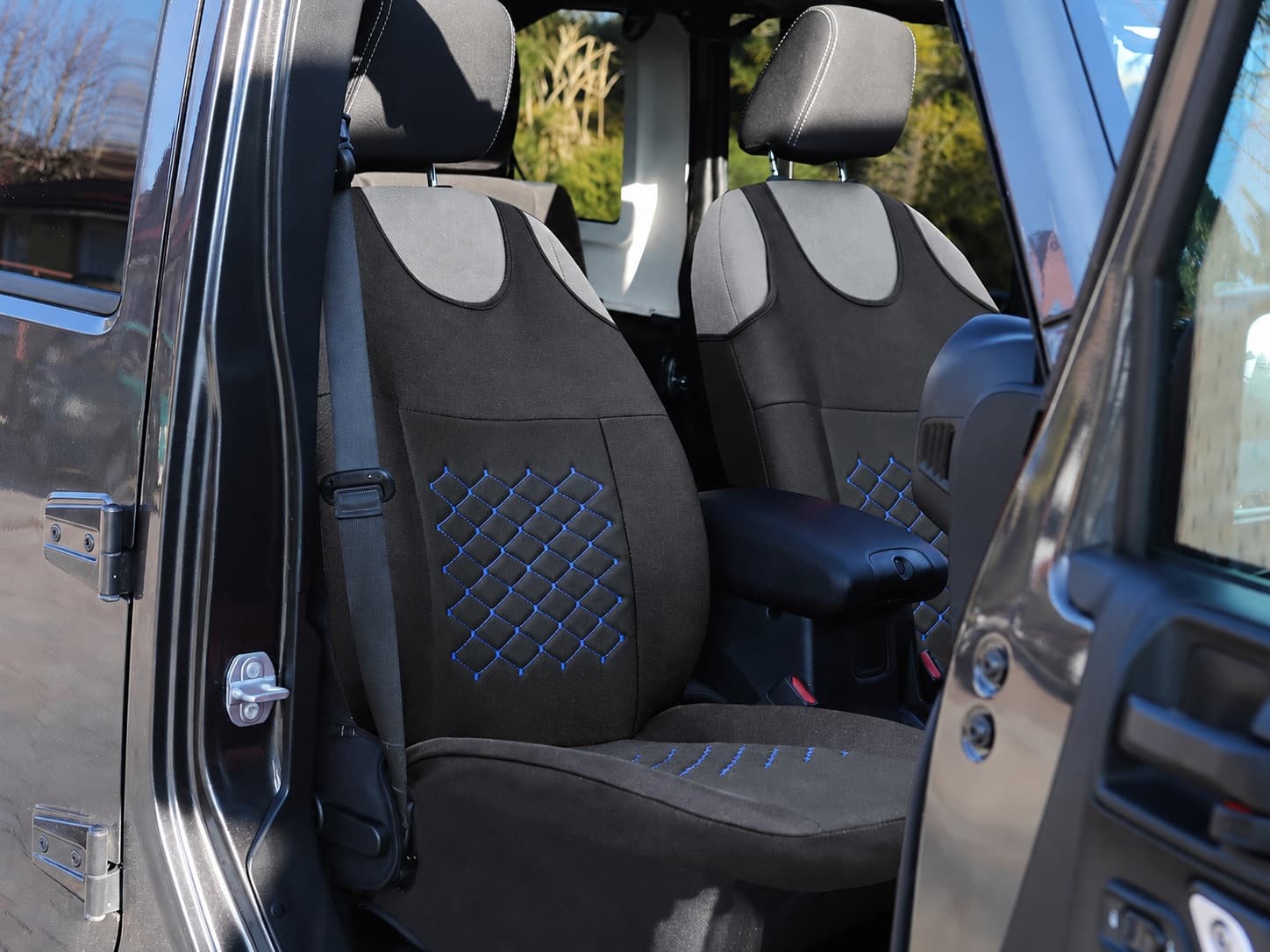 Coprisedili auto a maglietta Motive neri con cuciture blu montati sui sedili anteriori dell’auto